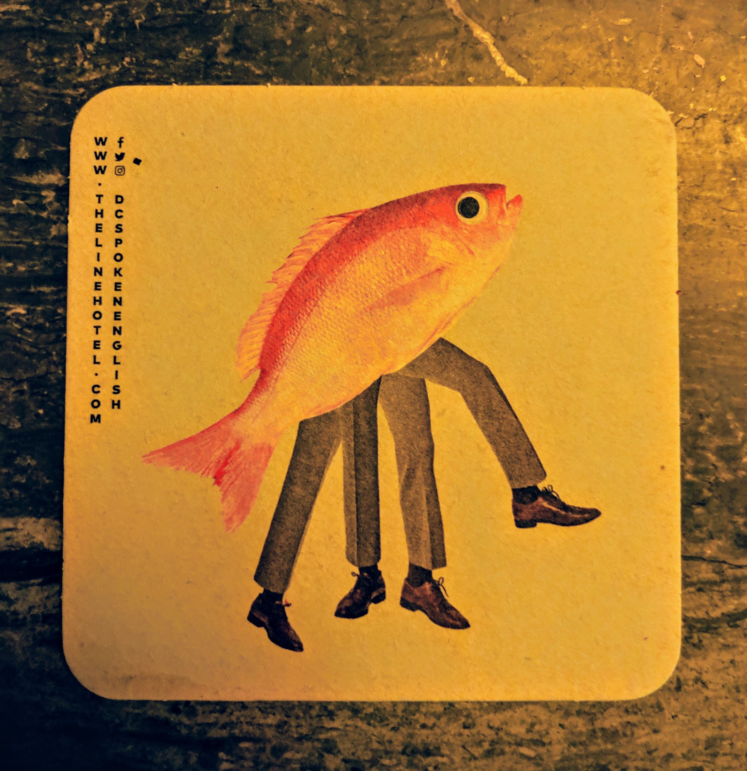 Photo of a coster that has a gold fish with four human legs in mens dress clothes.