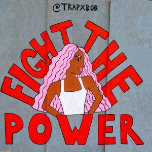 Photo of street art depicting a black women surounded by the words "Fight The Power"